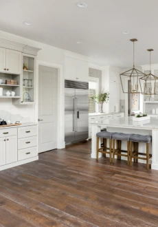 Modern, illuminated light wood floating staircase with glass railing, anchored by high-end, patterned wood-look plank tile flooring Nashville in gray and brown tones.