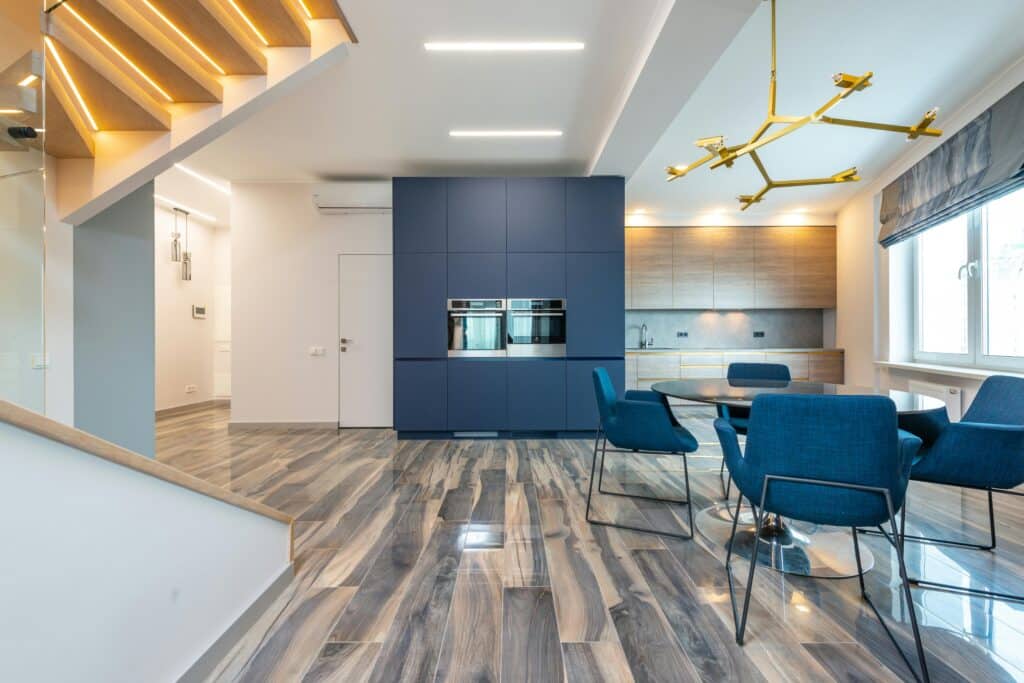 Traditional medium-tone oak hardwood flooring Nashville in a large, luxurious living space with a grand staircase, columns, and a central fireplace.