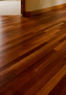 Wide, light natural wood plank flooring Nashville installed throughout a spacious, open-concept living and dining area with modern minimalist furniture, large windows, and a covered porch view.